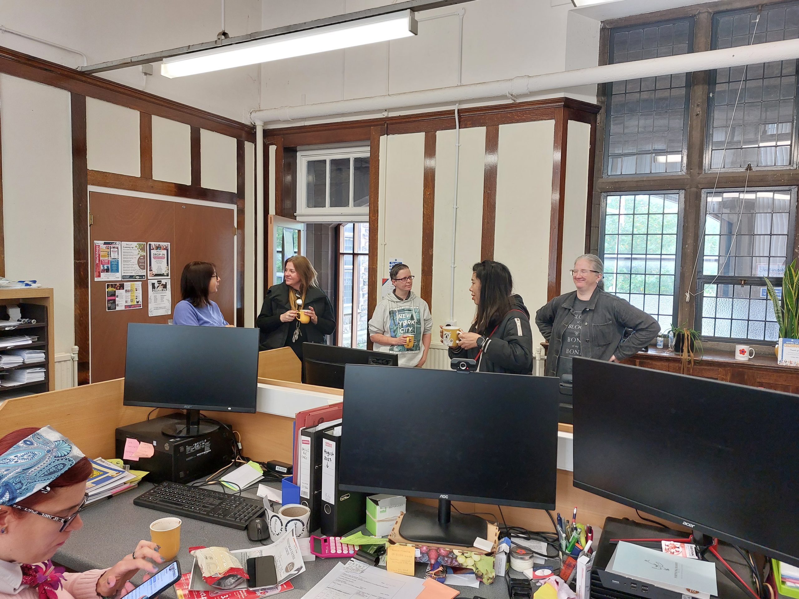 All volunteers gathering around dinking a cuppa in the office.