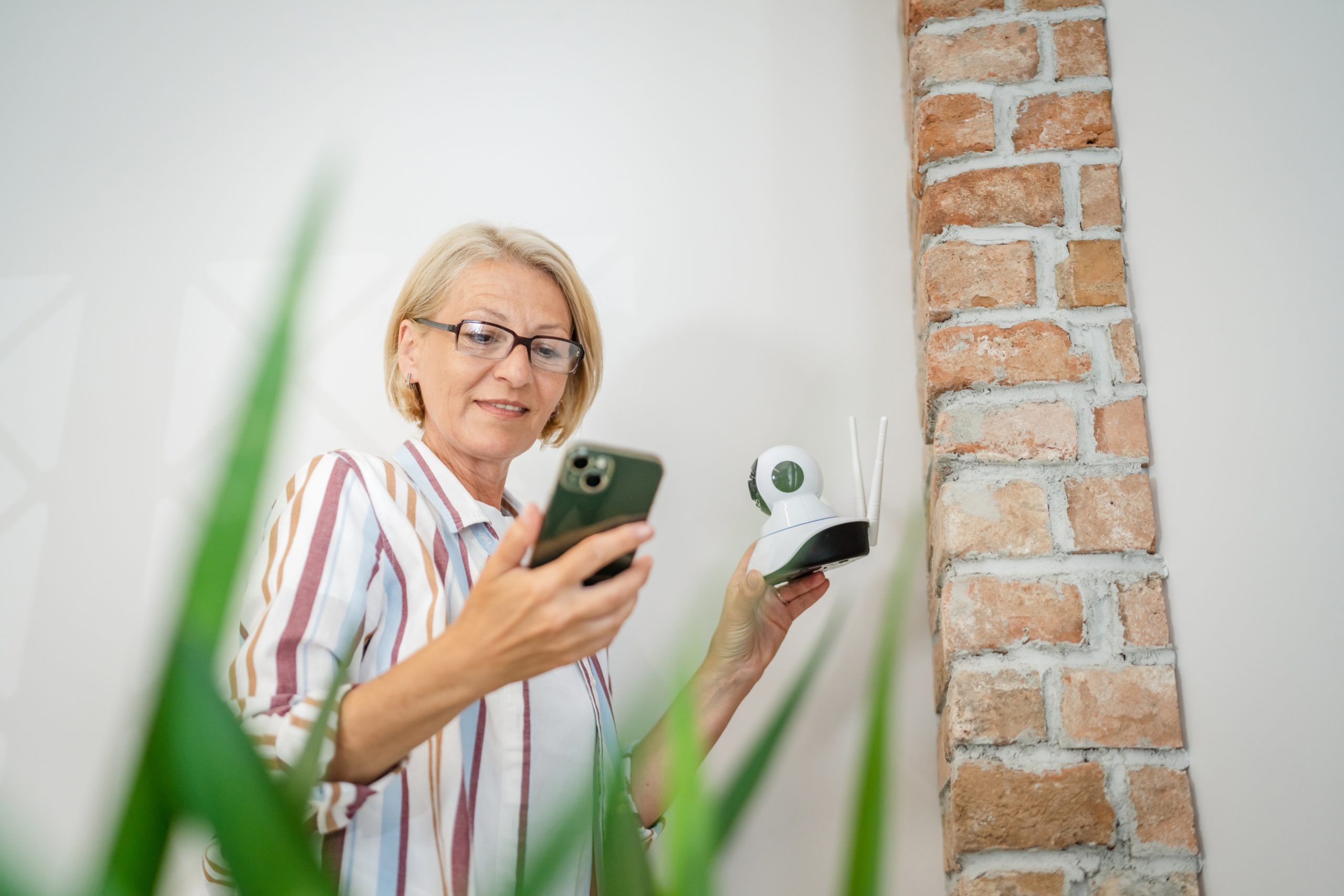 Senior woman looking at smartphone with cctv